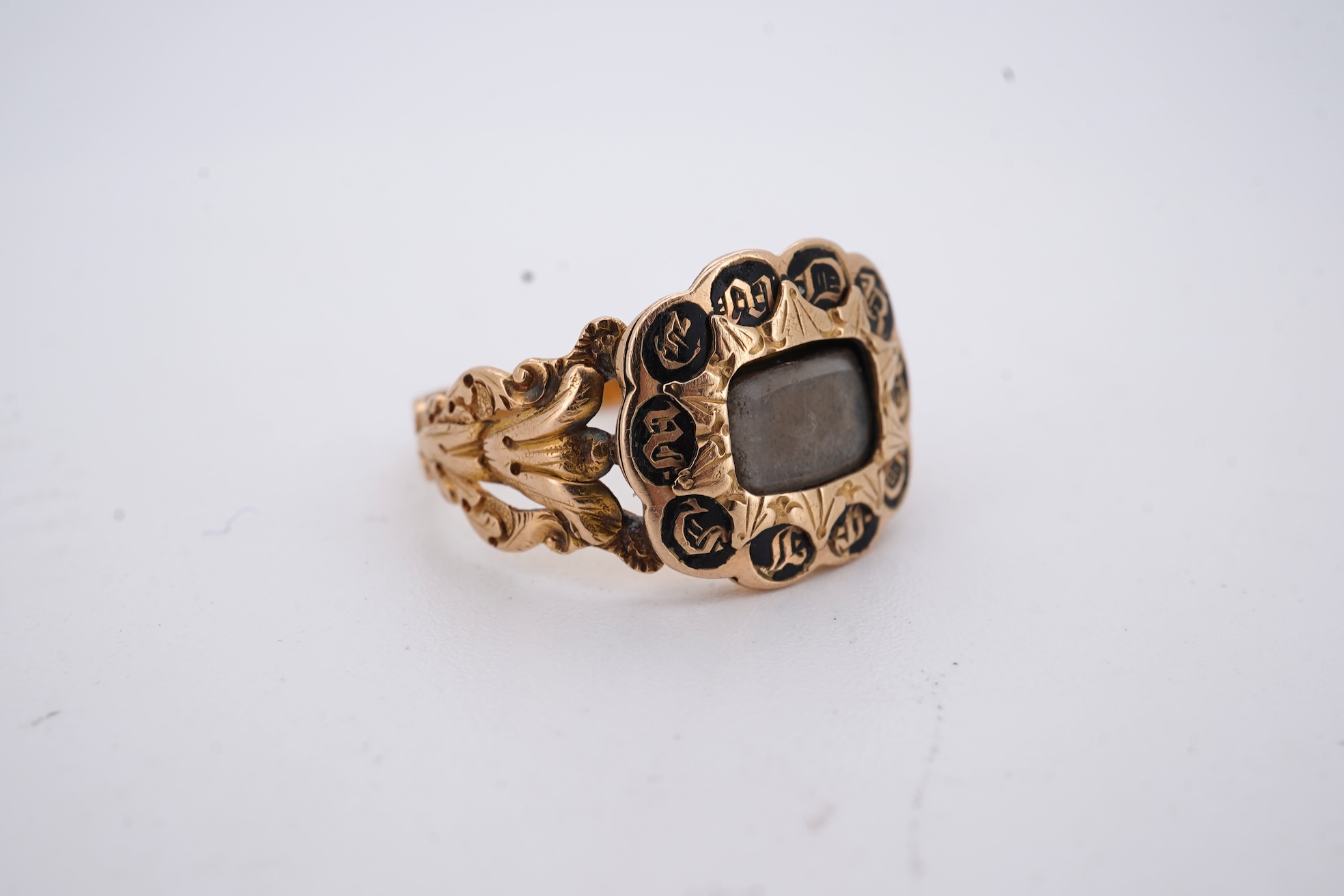 A William IV 18ct gold and black enamel 'In Memory' mourning ring, with hair beneath a central glazed panel, size N, gross weight 2.8 grams.
